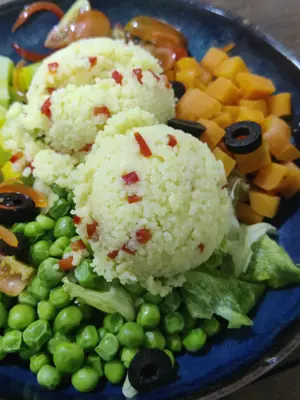 Steamed Moroccan cous cous salad with sweet green peas and carrots